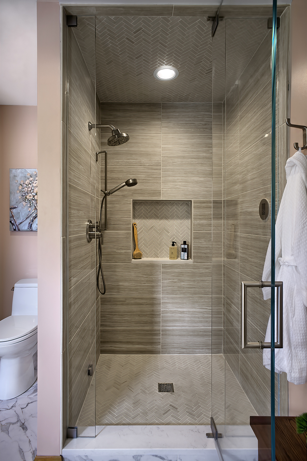 Shower with herringbone tile on floor and ceiling