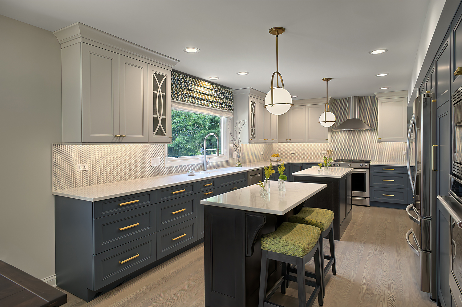 kitchen with three different colors of cabinets and two small islands.