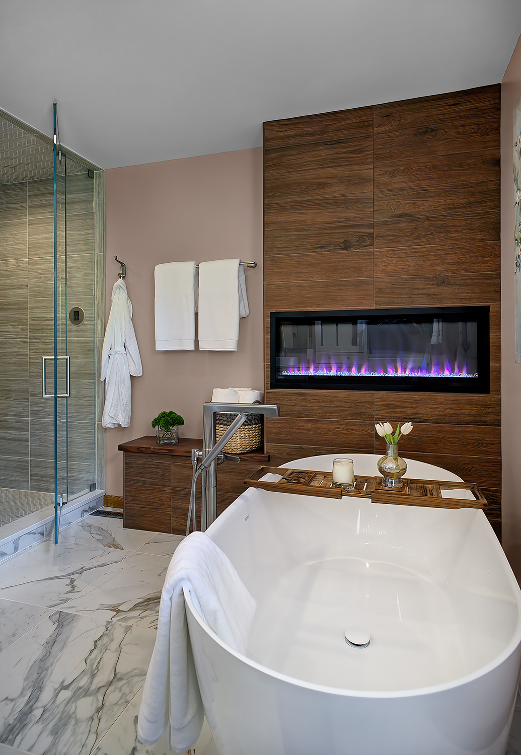 soaking tub adjacent to faux-wood wall with linear fireplace